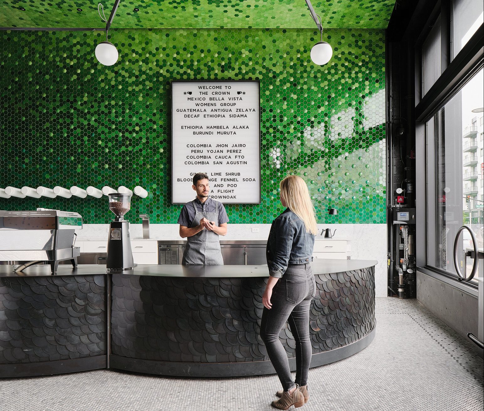A barista engaging with a customer inside a café