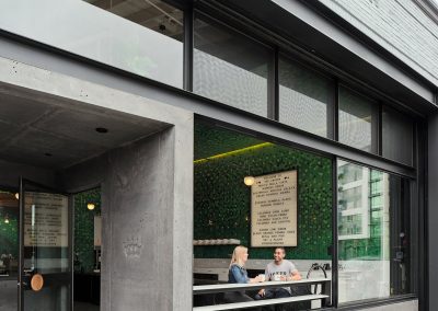 A street-level exterior view of a cafe's interior through large windows