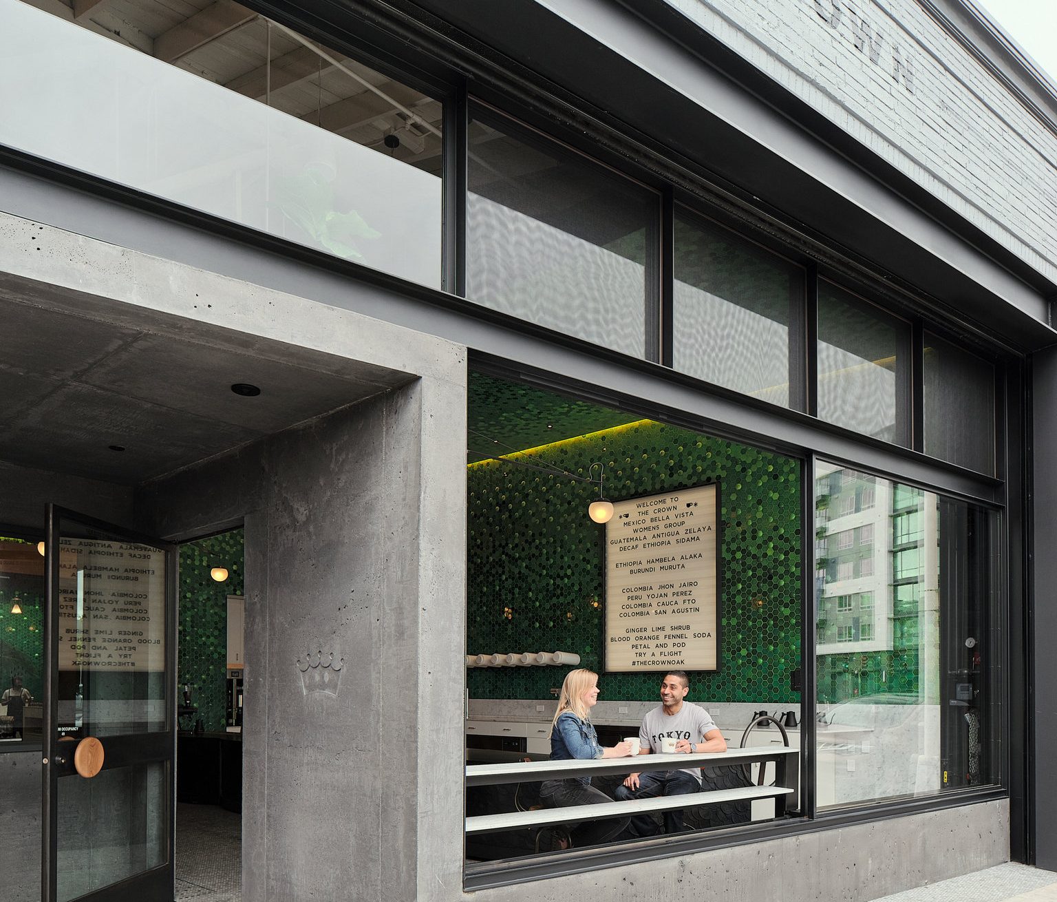 A street-level exterior view of a cafe's interior through large windows